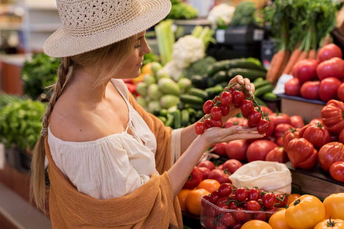 Turismo Rigenerativo - Ragazza che sceglie un grappolo di pomodori